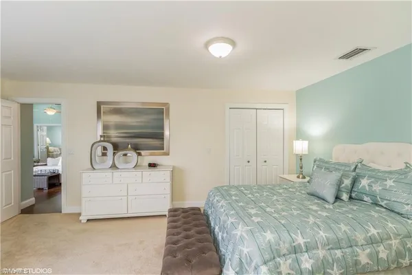 a spacious bedroom with a bed and a cabinets