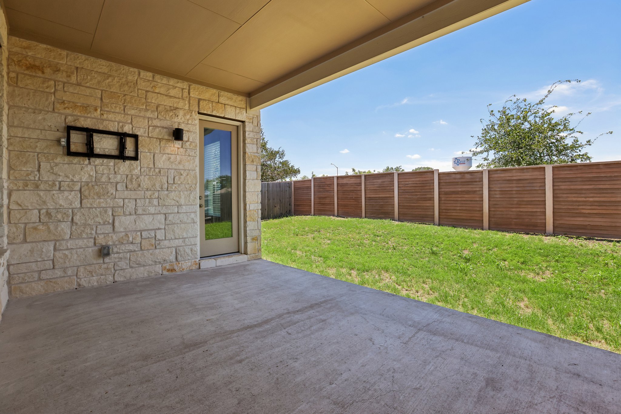 317 Independence Drive Kyle, TX 78640 - Photo 38 of 40 a view of a backyard with brick wall and a wooden fence
