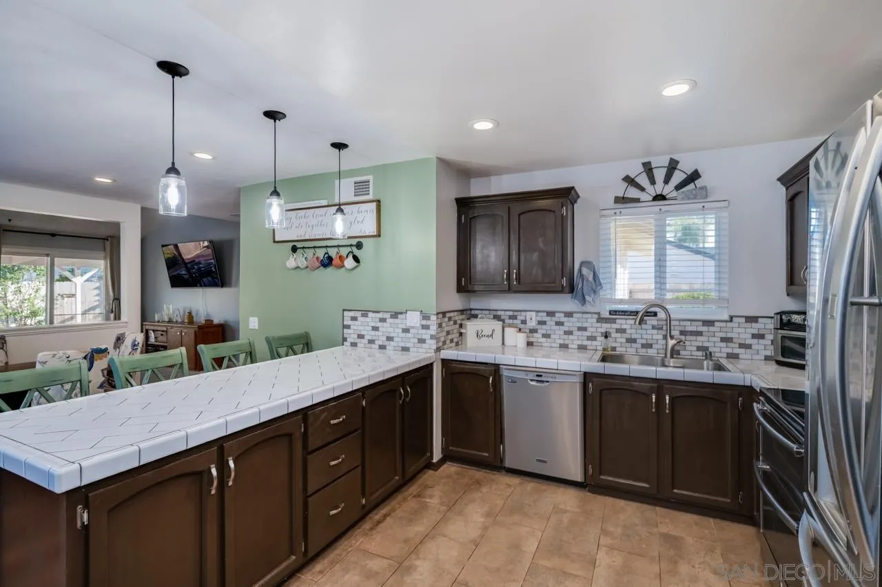 14027 Hermosillo Way Poway, CA 92064 - Photo 11 of 31 a kitchen with a stove and a wooden floor