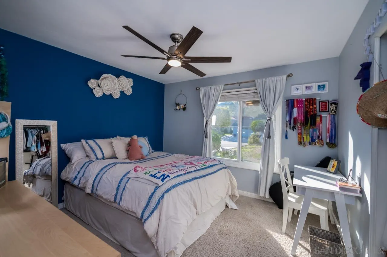 14027 Hermosillo Way Poway, CA 92064 - Photo 17 of 31 a bedroom with a large bed and a chandelier