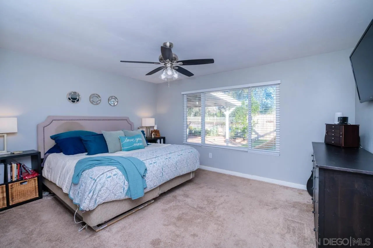 14027 Hermosillo Way Poway, CA 92064 - Photo 20 of 31 a bedroom with a large bed and a chandelier