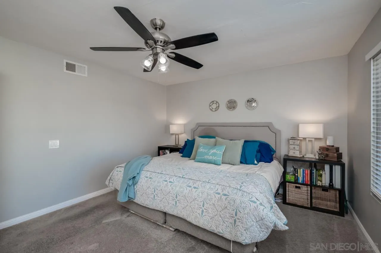 14027 Hermosillo Way Poway, CA 92064 - Photo 21 of 31 a bedroom with a large bed and a chandelier