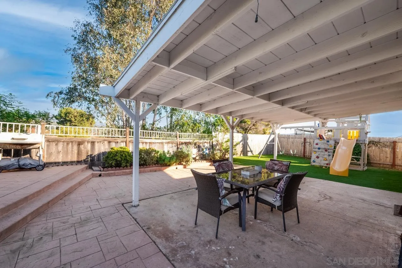 14027 Hermosillo Way Poway, CA 92064 - Photo 28 of 31 a view of a patio with a table and chairs under an umbrella with a patio