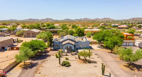 an aerial view of a house with a mountain