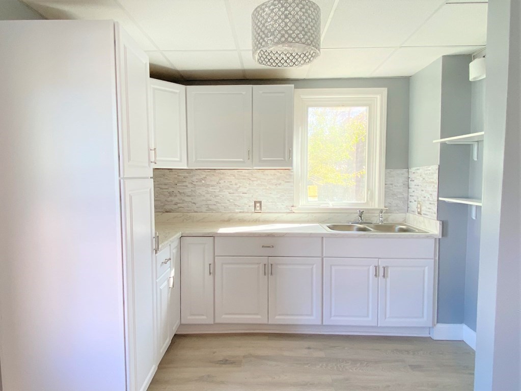 171 Snell Street Fall River, MA 02721 - Photo 9 of 34 a view of cabinets a sink and a stove in a room