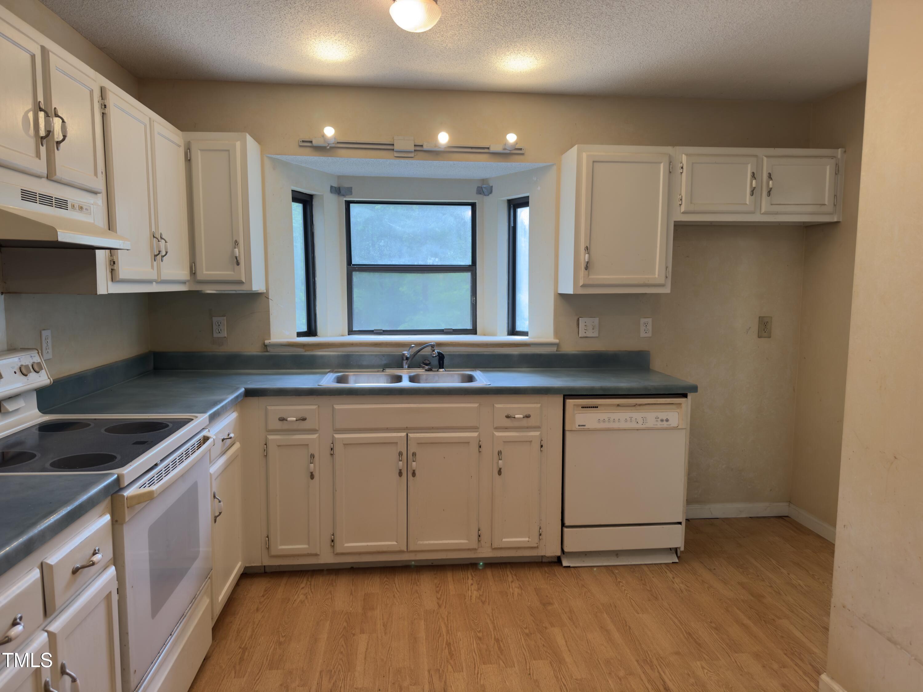 5767 Forest Lawn Court Raleigh, NC 27612 - Photo 4 of 17 a kitchen with granite countertop a sink and a stove