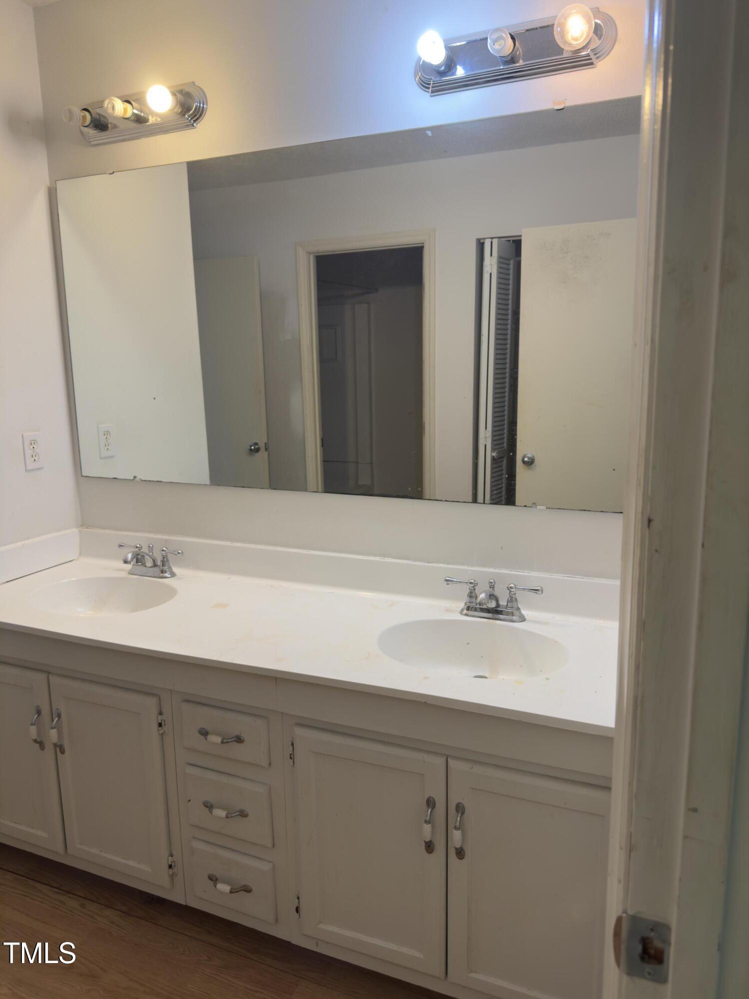 5767 Forest Lawn Court Raleigh, NC 27612 - Photo 9 of 17 a bathroom with a double vanity sink and mirror