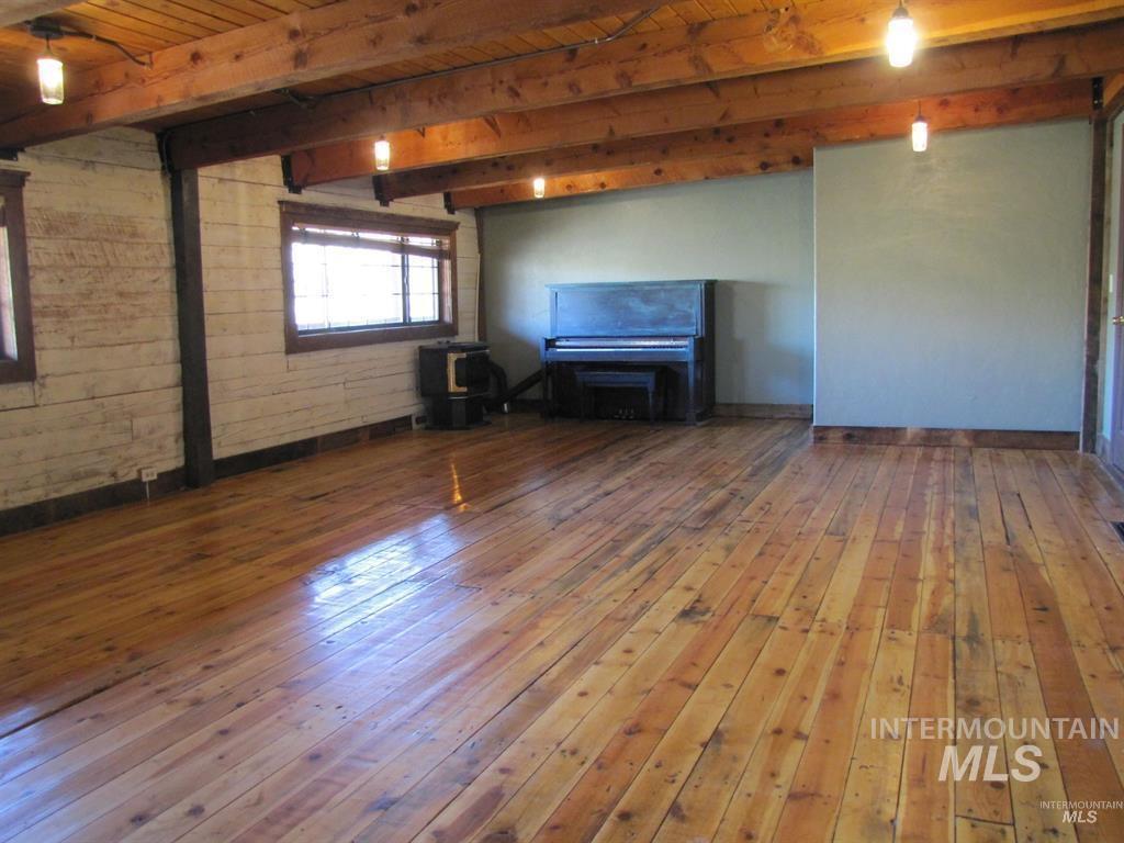 11500 Brownlee Road Sweet, ID 83670 - Photo 8 of 22 Unfurnished living room featuring dark wood-style flooring and a wood ceiling with exposed beams