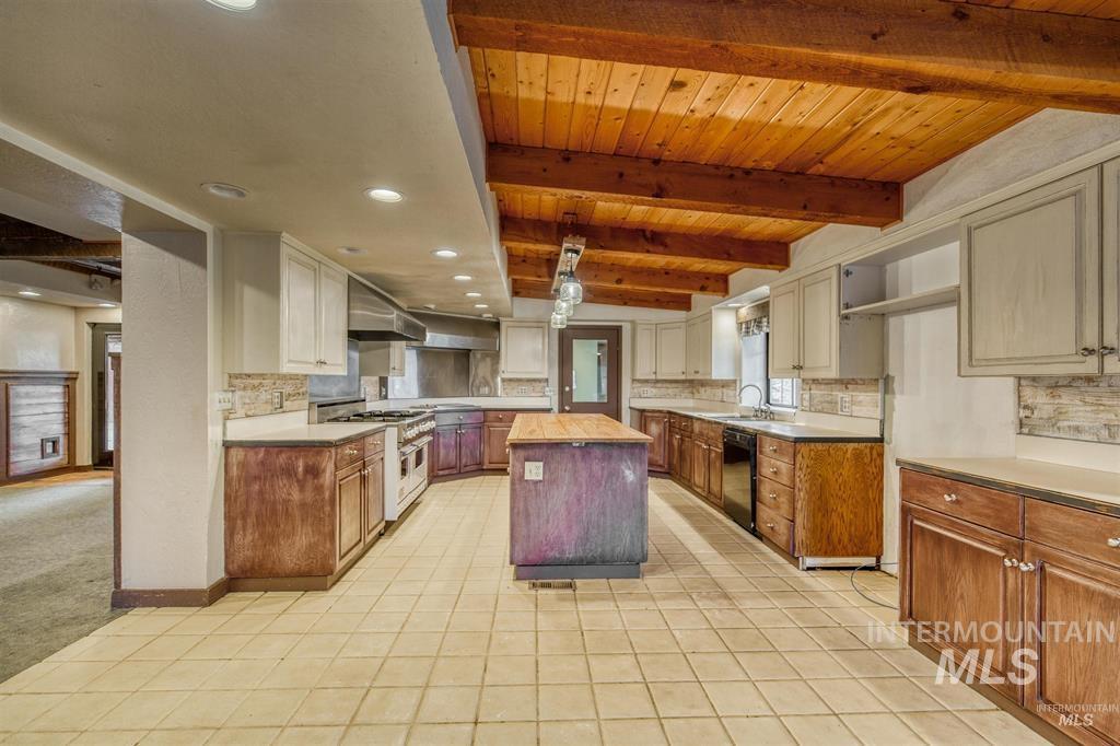 11500 Brownlee Road Sweet, ID 83670 - Photo 13 of 22 Dual tone kitchen featuring a center island, decorative backsplash, dual tone cabinetry, double oven range, and dishwasher