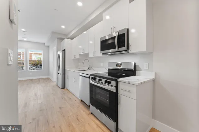 a kitchen with stainless steel appliances granite countertop a stove a sink and a microwave