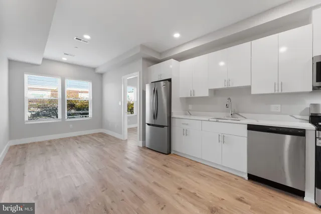 a kitchen with a refrigerator sink and cabinets