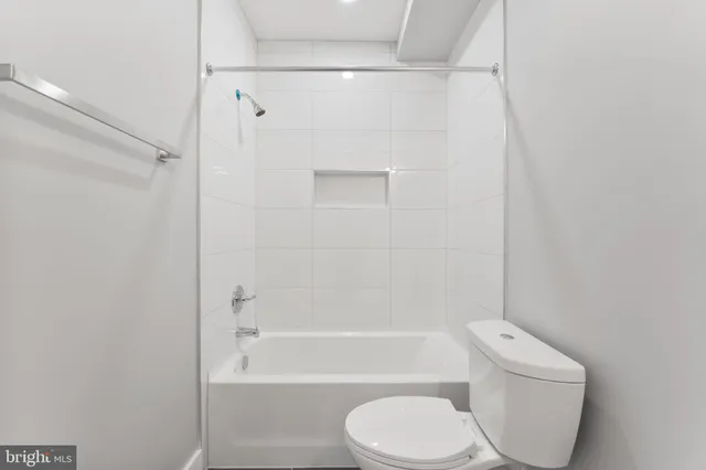 a white toilet and tub next to a white cabinet