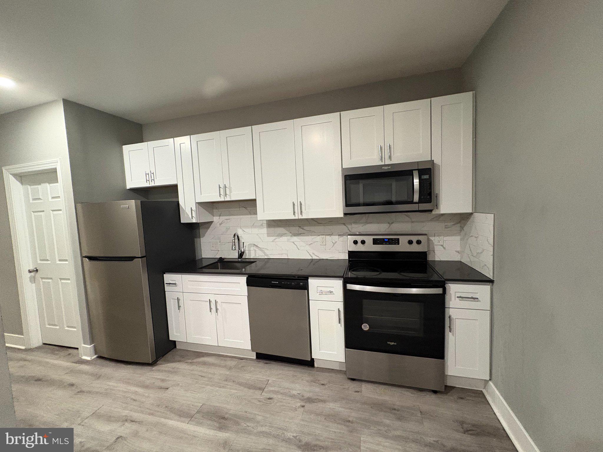 1813 South 23rd Street, Unit 2 Philadelphia, PA 19145 - Photo 3 of 20 a kitchen with a refrigerator stove and microwave