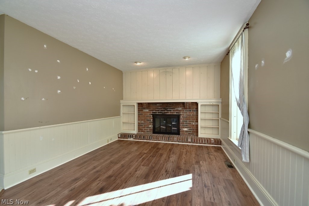 9815 Ravenna Road Chardon, OH 44024 - Photo 5 of 25 Living Room with wood burning fireplace. Original hardwood flooring under the laminate