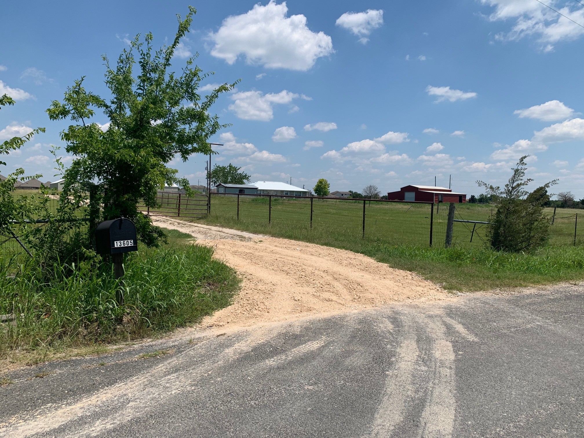 View of dirt / gravel road with a gated entry and a rural view