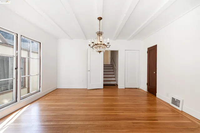 a view of a room with wooden floor and chandelier