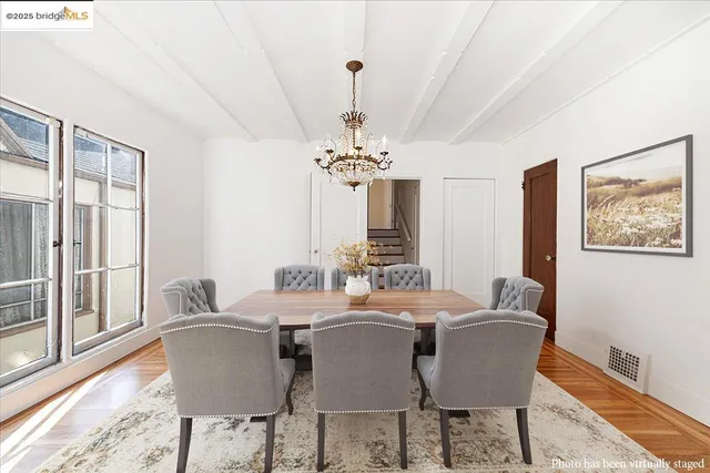 a dining room with furniture a chandelier and wooden floor