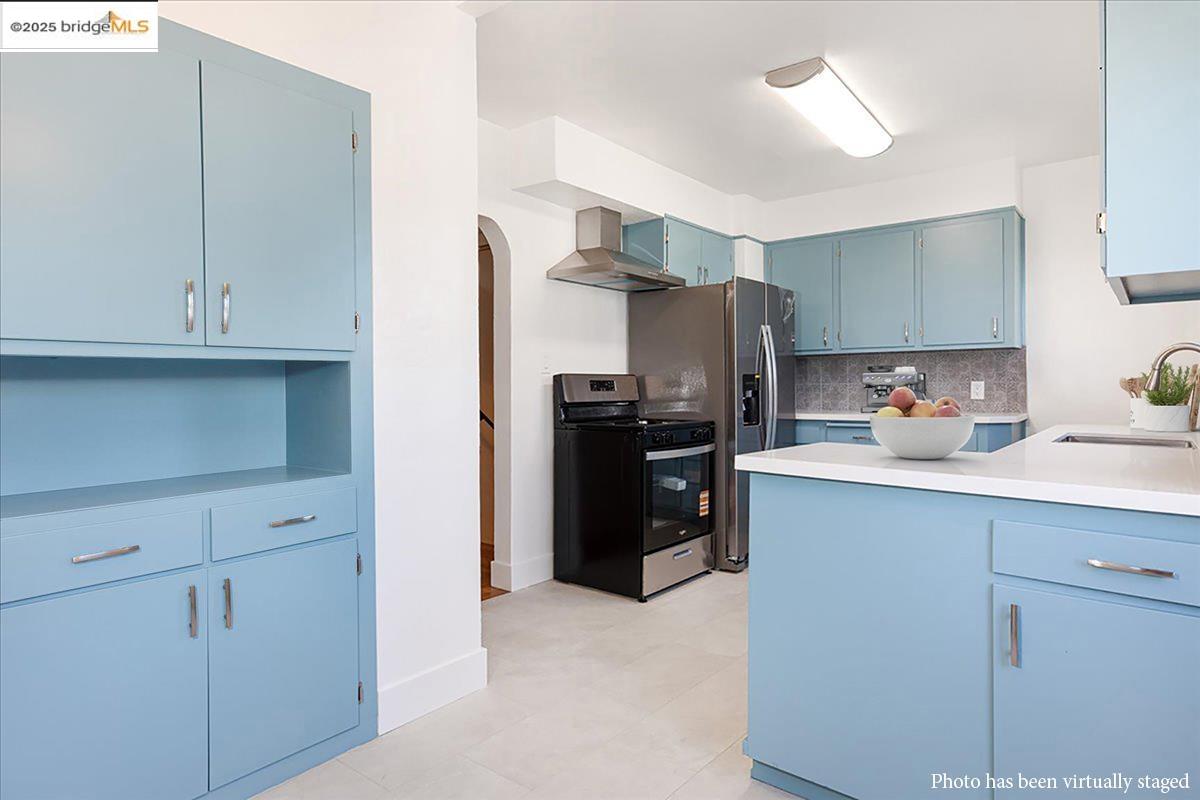 7601 Holly Street Oakland, CA 94621 - Photo 22 of 51 a kitchen with stainless steel appliances a refrigerator and cabinets