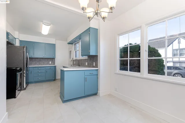 an empty room with windows and chandelier