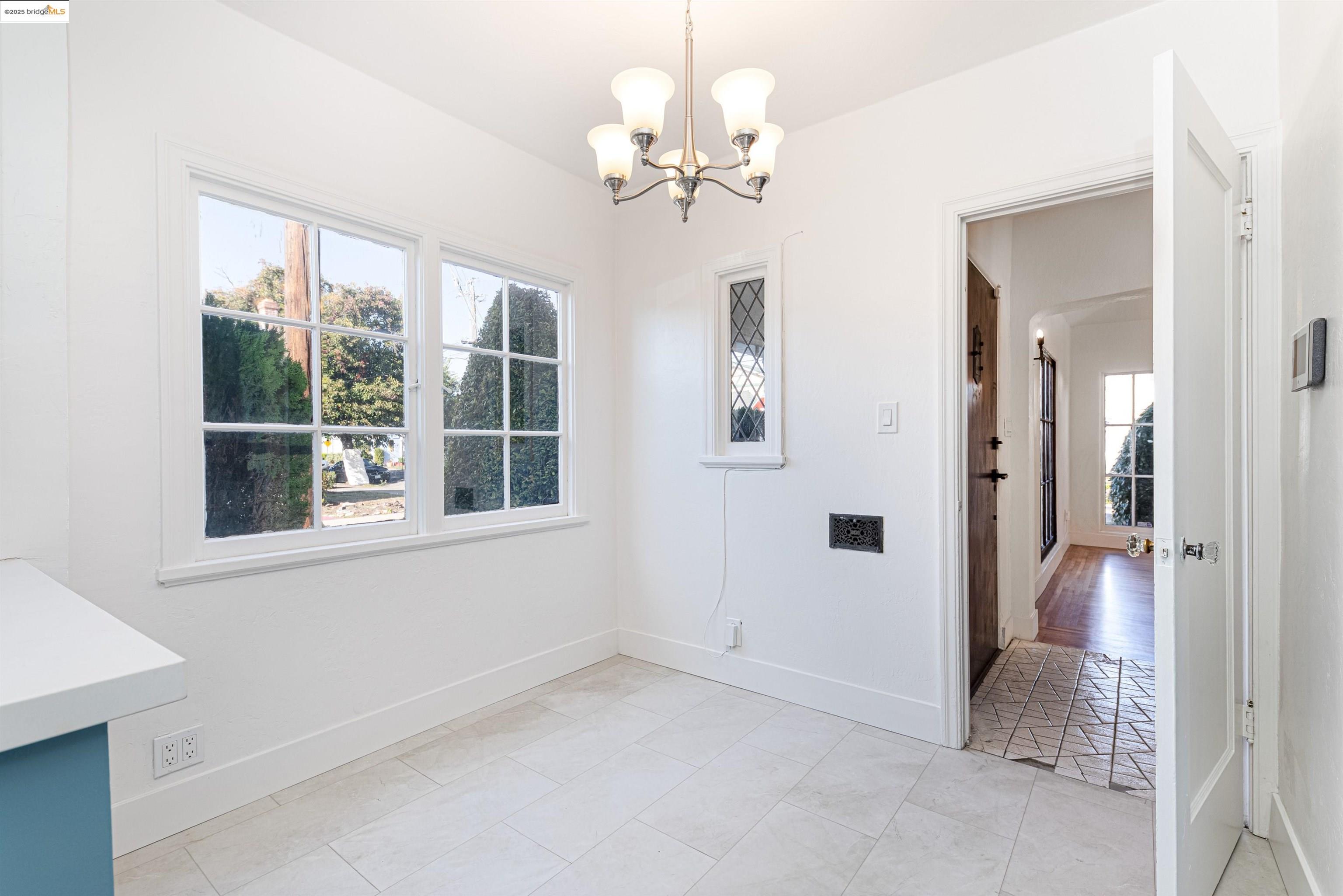 7601 Holly Street Oakland, CA 94621 - Photo 25 of 51 an empty room with windows and chandelier