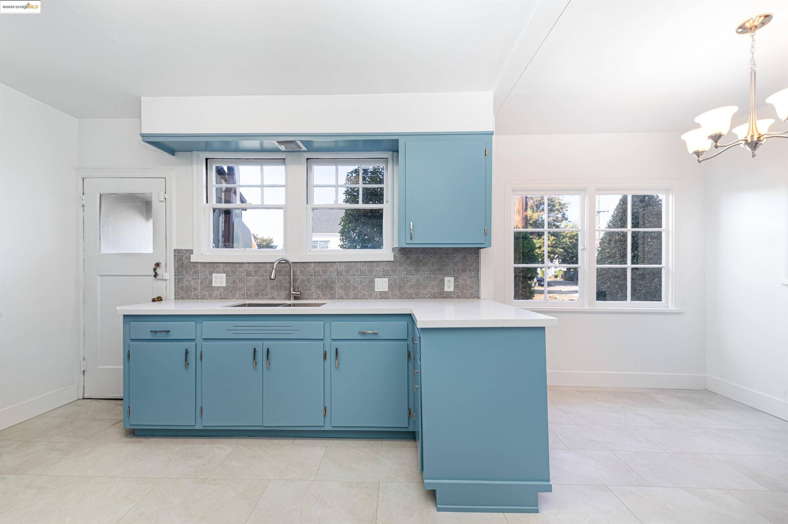 7601 Holly Street Oakland, CA 94621 - Photo 29 of 51 a kitchen with a sink window and cabinets