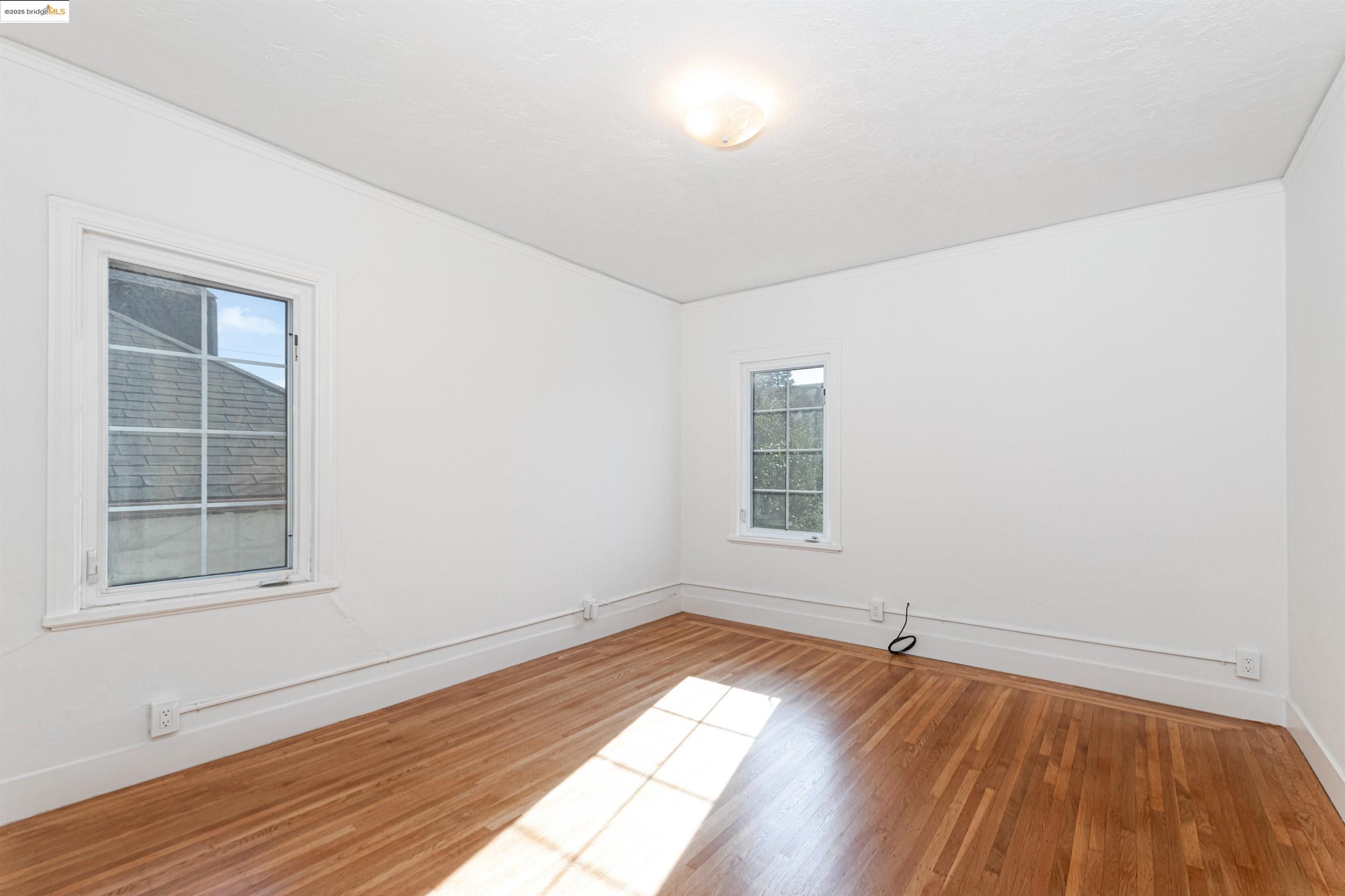 7601 Holly Street Oakland, CA 94621 - Photo 33 of 51 an empty room with wooden floor and windows