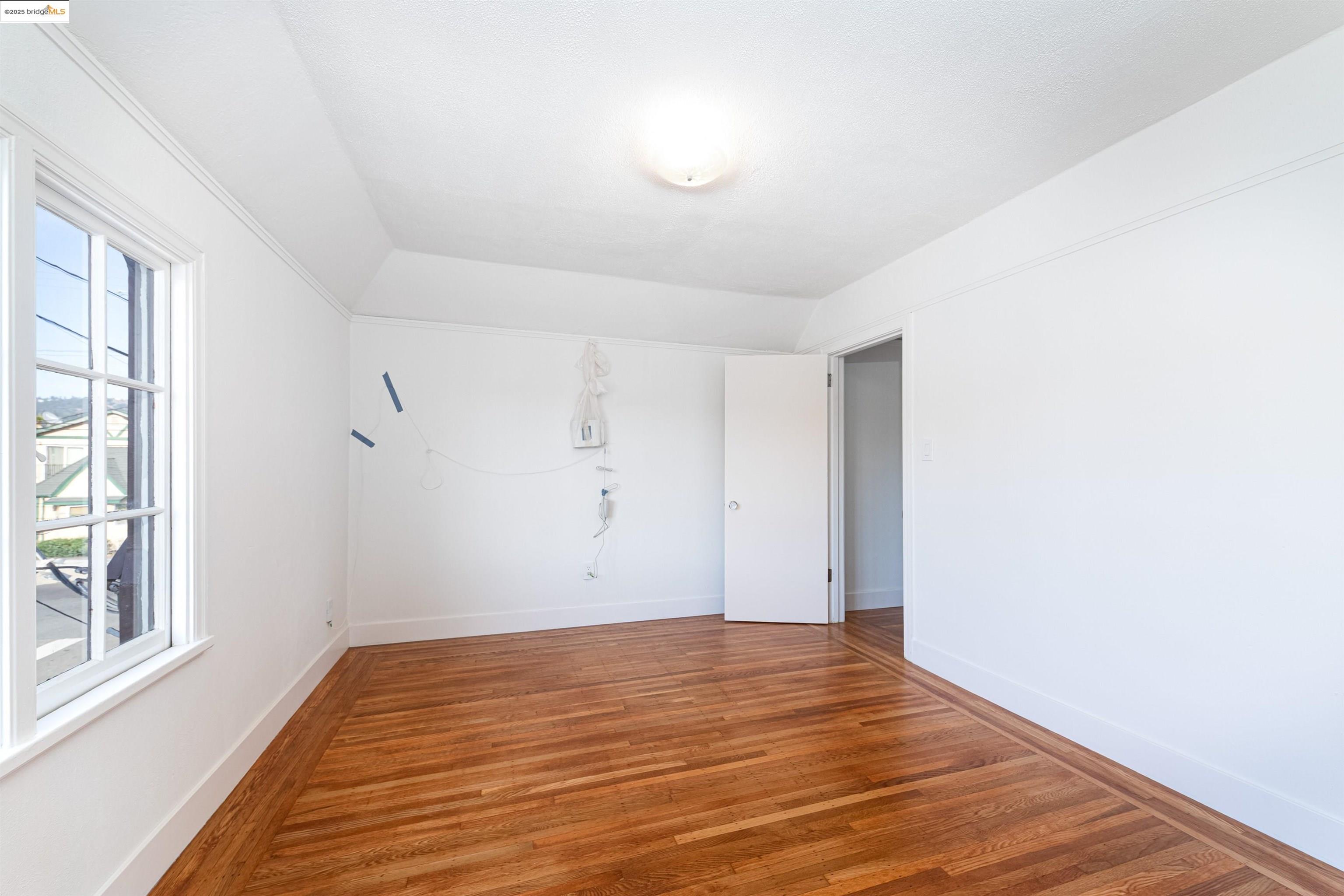 7601 Holly Street Oakland, CA 94621 - Photo 38 of 51 a view of empty room with wooden floor and fan