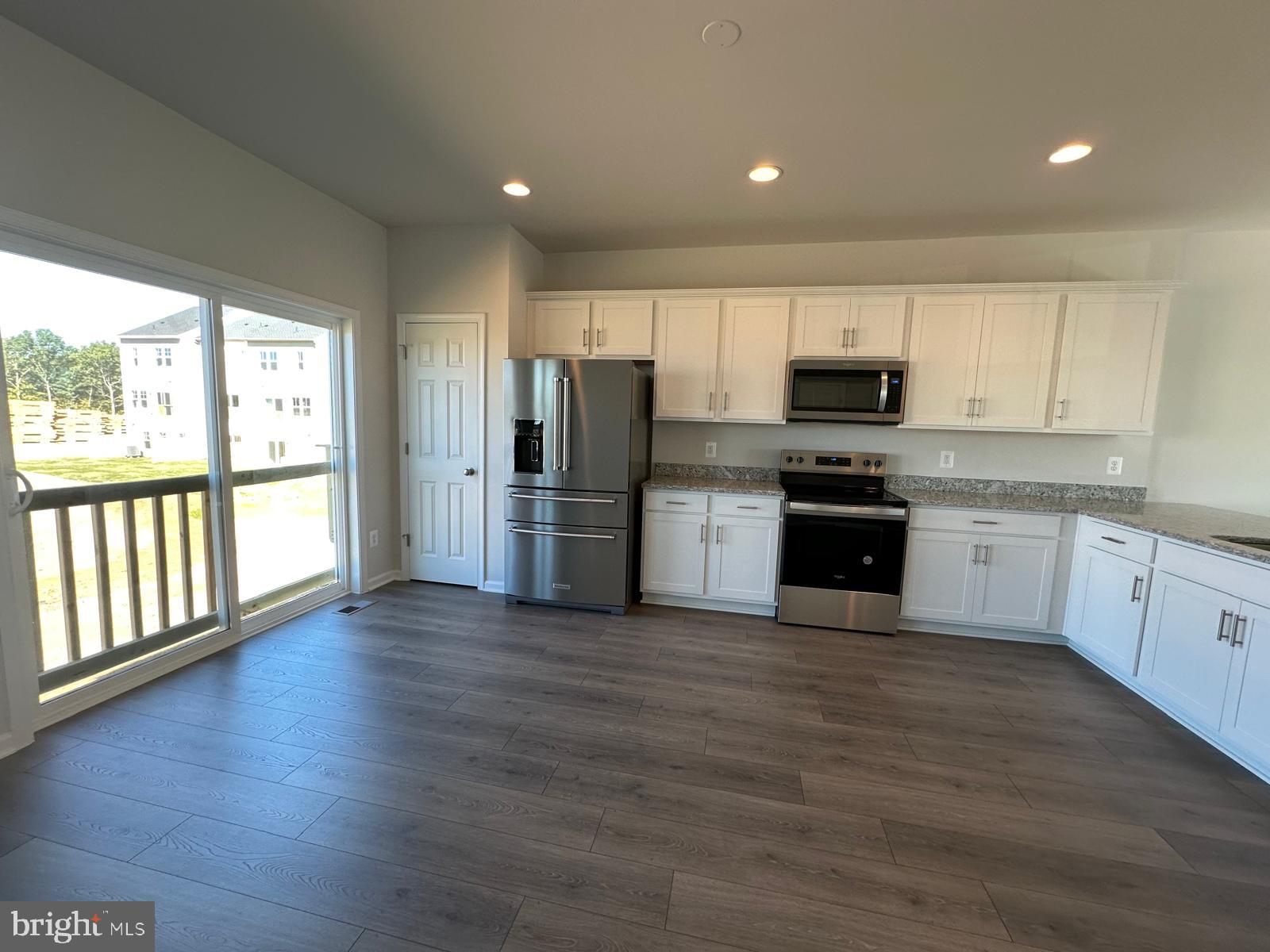 148 Galaxy Place Stephenson, VA 22656 - Photo 6 of 7 a kitchen with stainless steel appliances a stove top oven a refrigerator with white cabinets and wooden floor