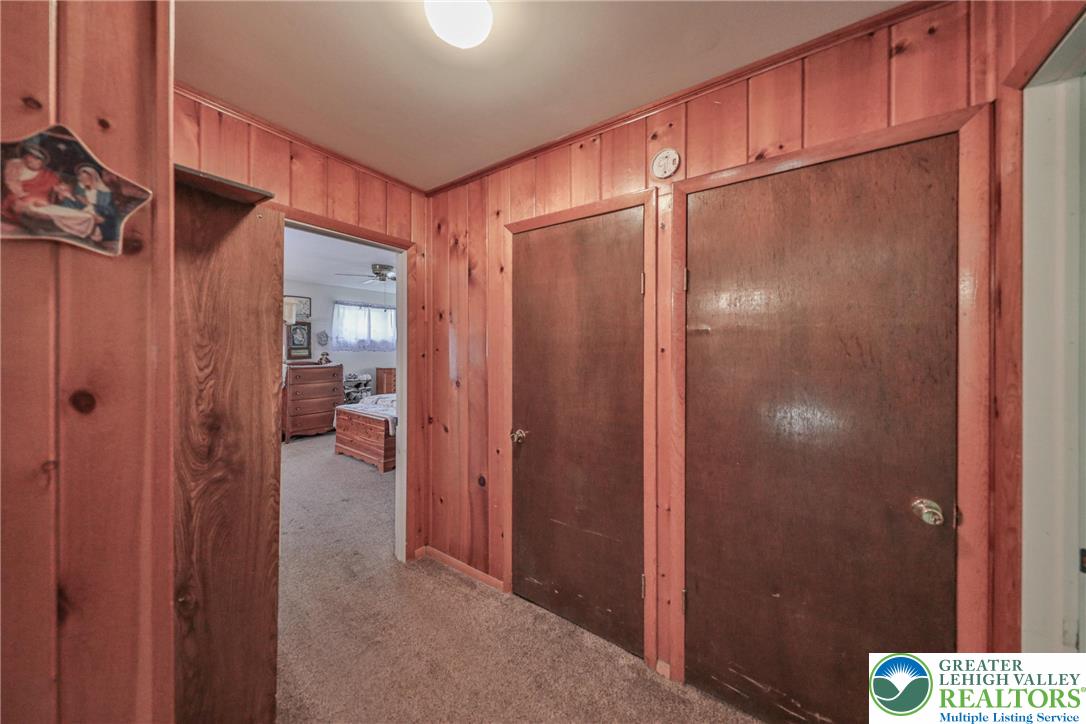 331 Cranberry Creek Road Cresco, PA 18326 - Photo 28 of 95 Wood paneling and carpeted flooring define this cozy interior hallway with access to an adjacent bedroom.