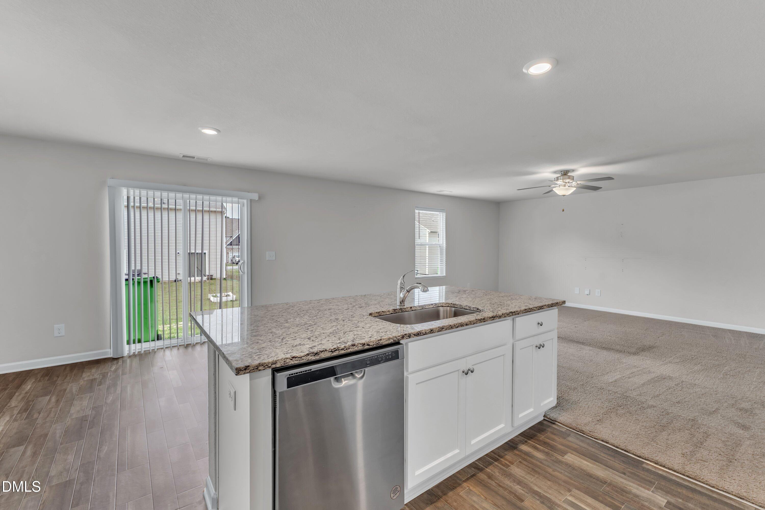 717 Little Patch Street Zebulon, NC 27597 - Photo 18 of 36 a kitchen with sink cabinets and wooden floor