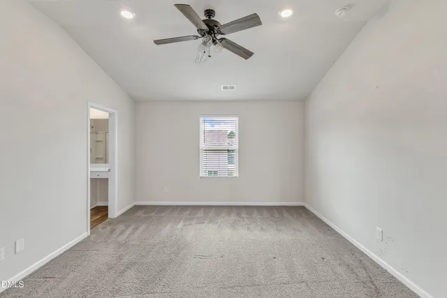 an empty room with a ceiling fan and window