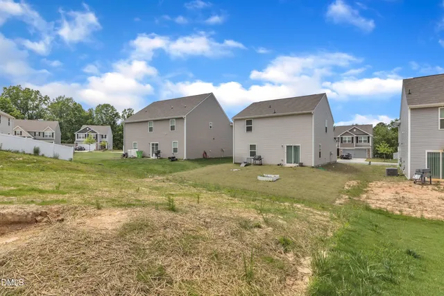 a view of a house with a big yard and large tree
