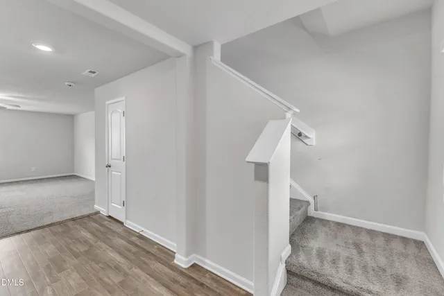 a view of a hallway with wooden floor and entryway