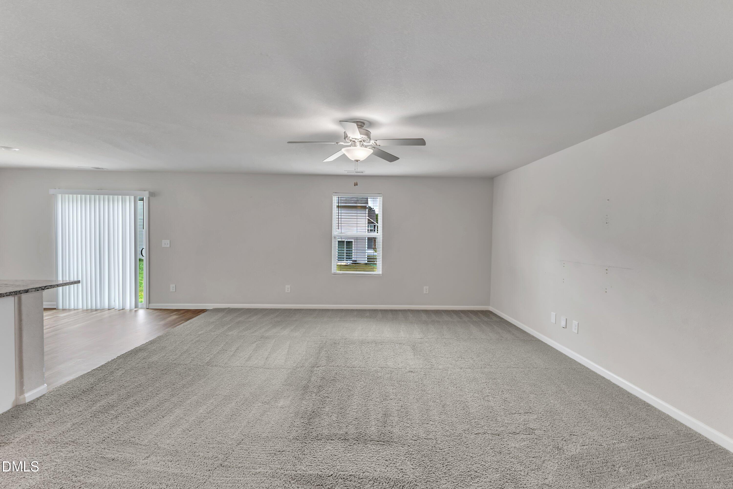 717 Little Patch Street Zebulon, NC 27597 - Photo 9 of 36 an empty room with chandelier fan and windows