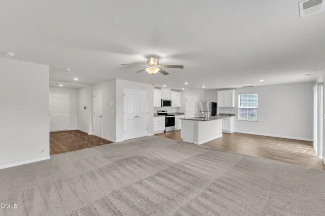 a view of a kitchen with kitchen island a sink stainless steel appliances and cabinets