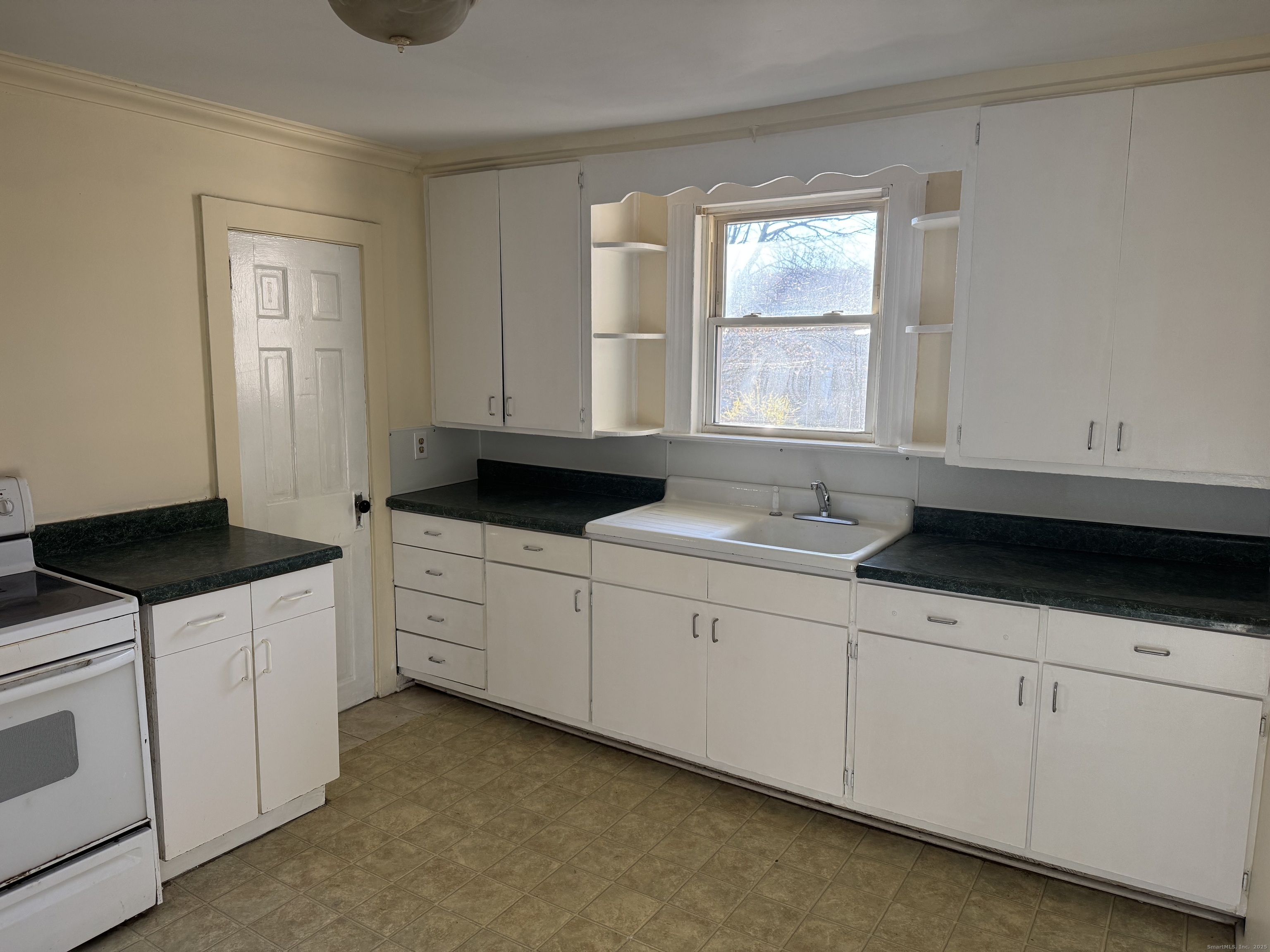 31 Wolcott Avenue, Unit 2 Torrington, CT 06790 - Photo 3 of 22 a kitchen with granite countertop a sink white cabinets and a stove