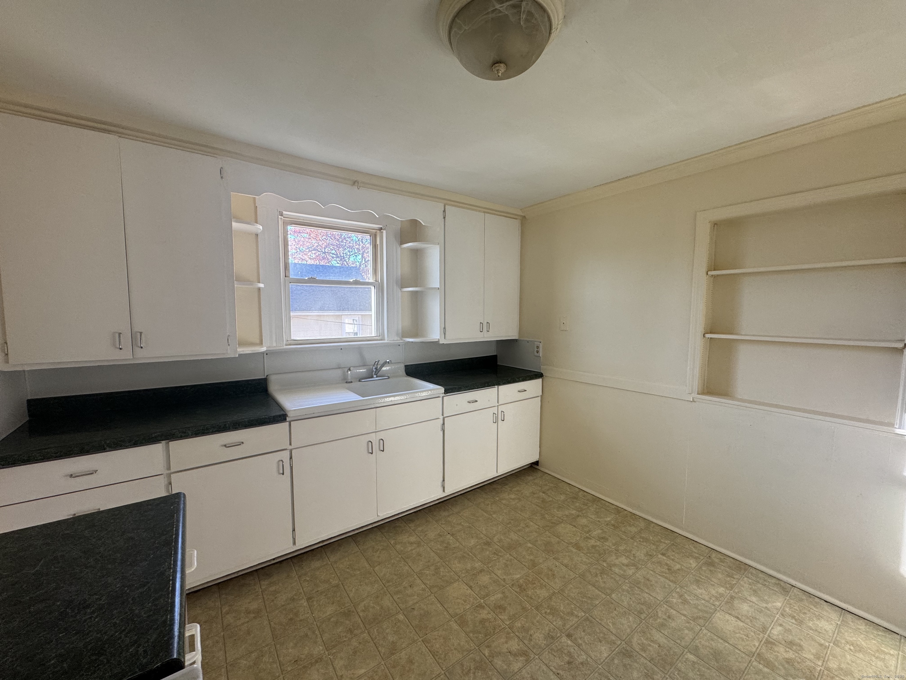 31 Wolcott Avenue, Unit 2 Torrington, CT 06790 - Photo 4 of 22 a kitchen with granite countertop white cabinets and sink