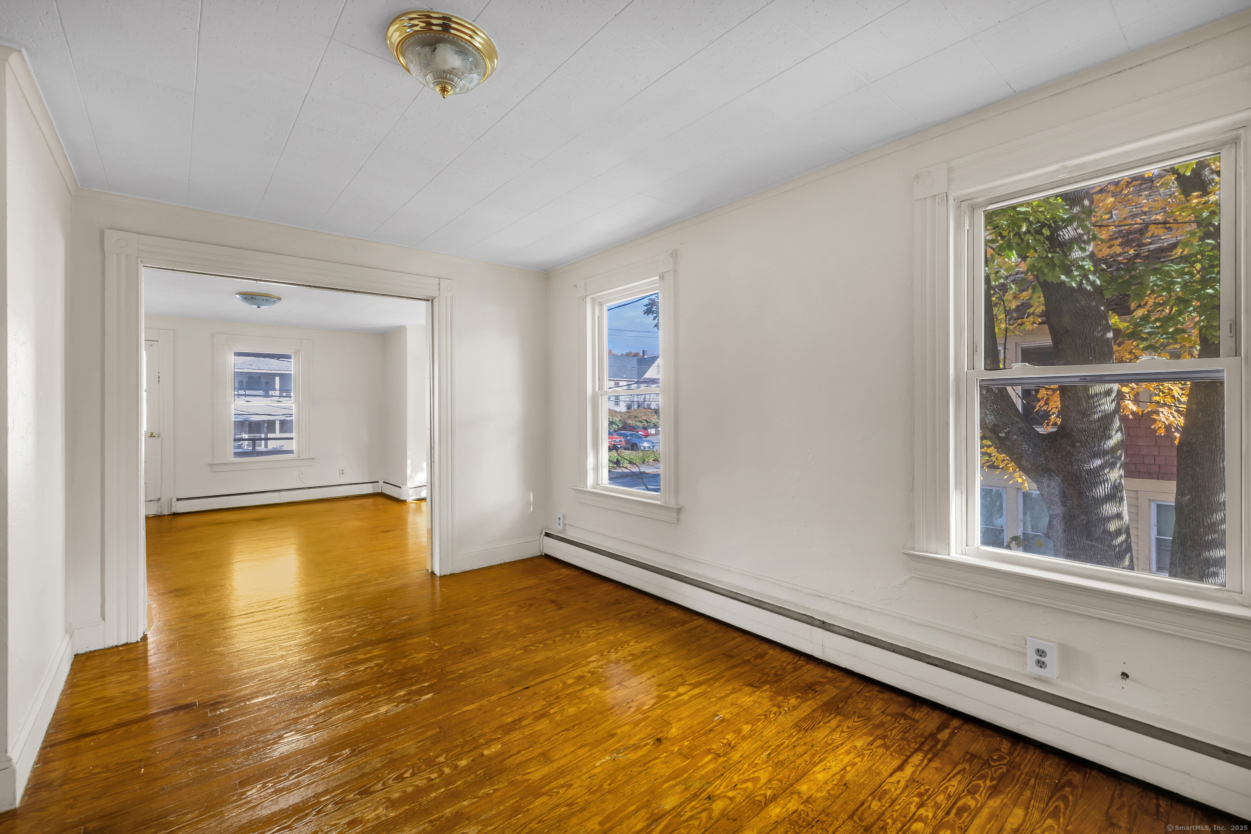 31 Wolcott Avenue, Unit 2 Torrington, CT 06790 - Photo 10 of 22 a view of an empty room with a window and wooden floor