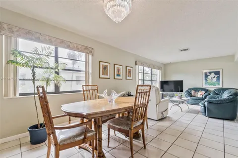 a view of a dining room with furniture a chandelier and wooden floor