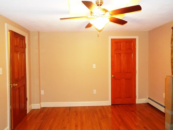 219 Prospect Street Ashland, MA 01721 - Photo 15 of 21 an empty room with wooden floor and a ceiling fan