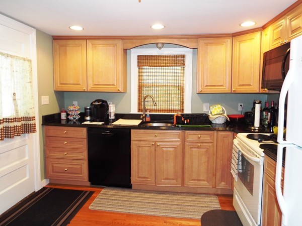 219 Prospect Street Ashland, MA 01721 - Photo 2 of 21 a kitchen with granite countertop a refrigerator a sink a stove a microwave and wooden cabinets