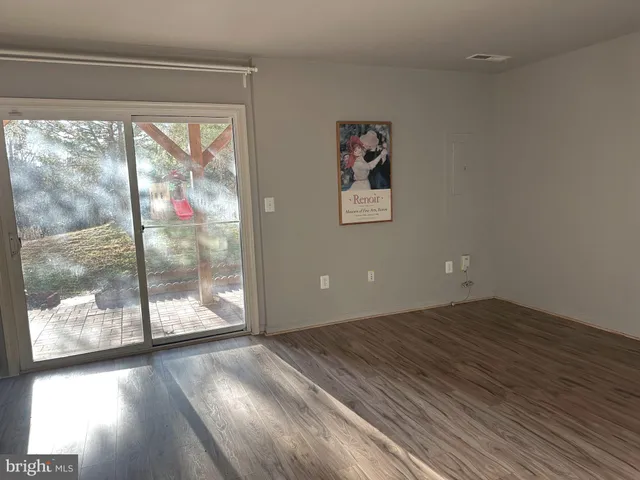 a view of a big room with wooden floor and doors