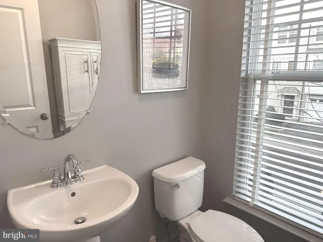a bathroom with a toilet a sink and a mirror