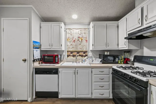 a kitchen with a dining table cabinets appliances and cabinets