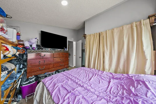 a view of a bedroom with furniture and a flat screen tv