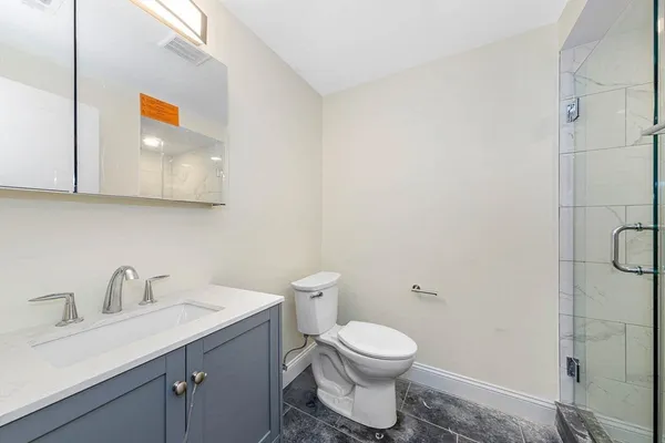 a bathroom with a toilet sink and mirror