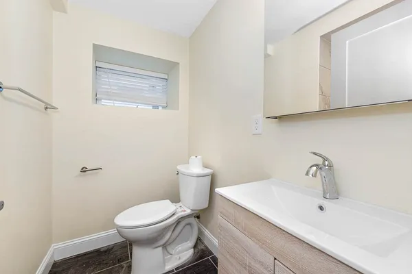 a bathroom with a sink toilet and mirror