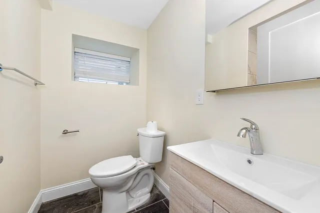 a bathroom with a sink toilet and mirror