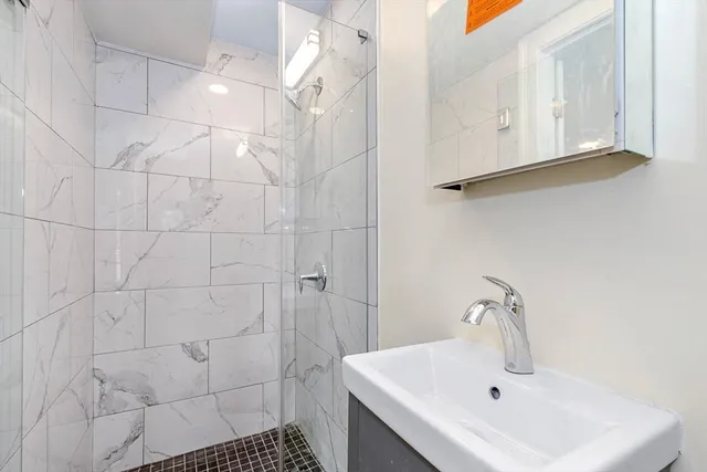 a bathroom with a sink a toilet and shower