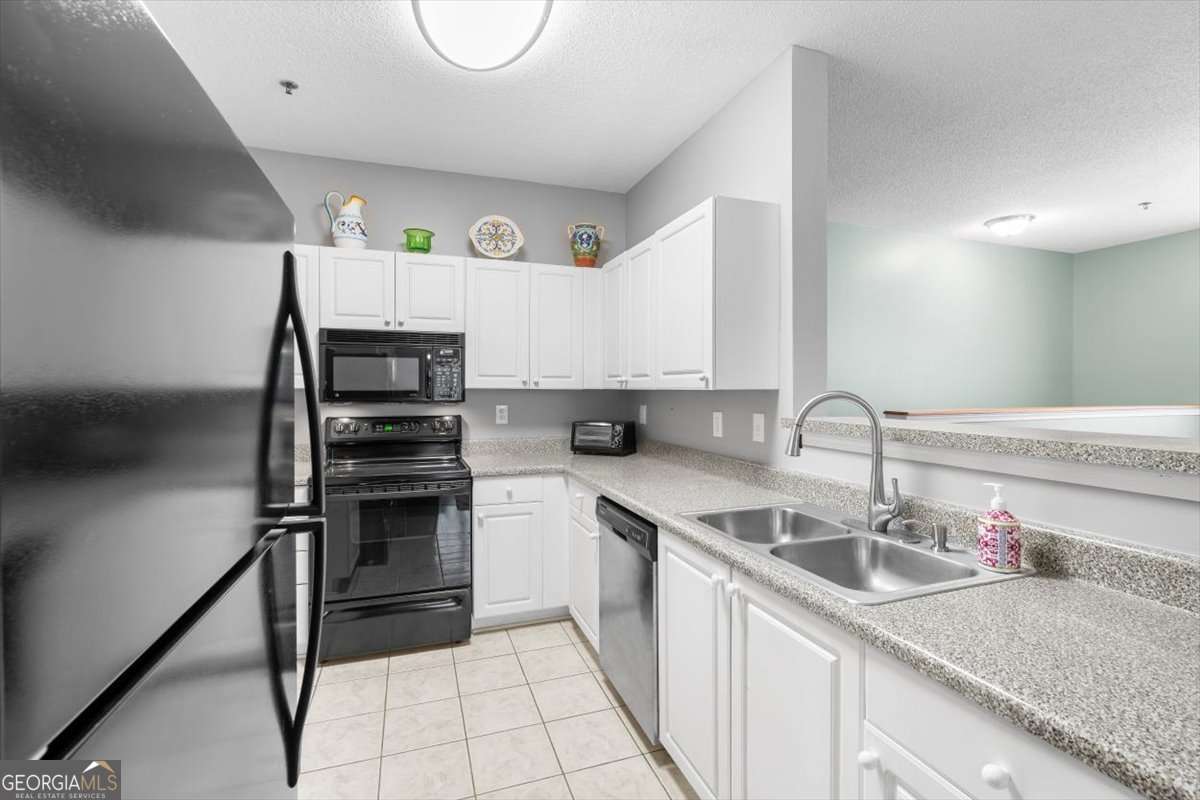 803 Spring Heights Lane, Unit 8 Smyrna, GA 30080 - Photo 13 of 46 a kitchen with a sink a counter top space cabinets and stainless steel appliances
